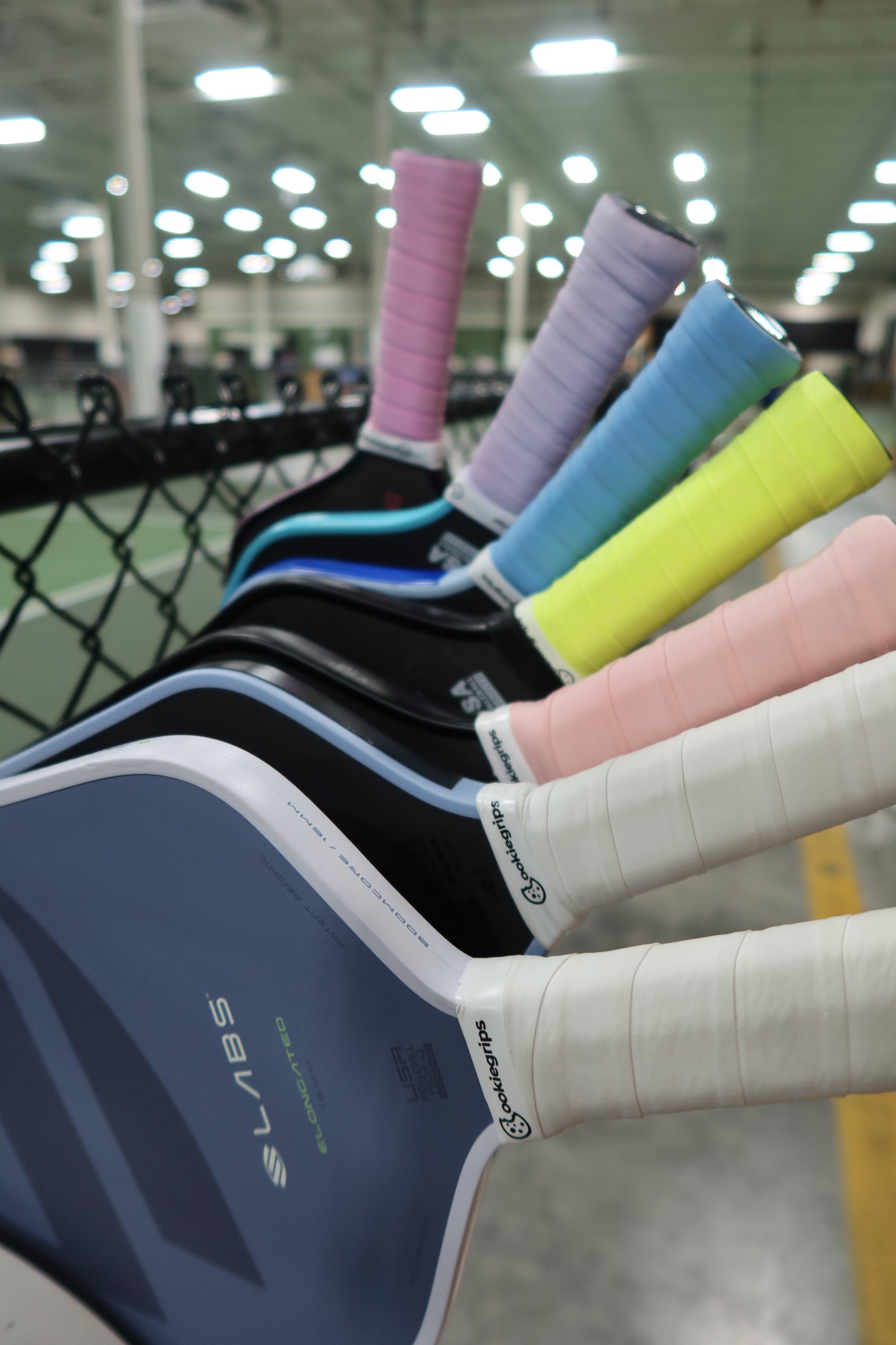 Hands wrapping a cookiegrips doughy grips pickleball overgrip around a paddle handle