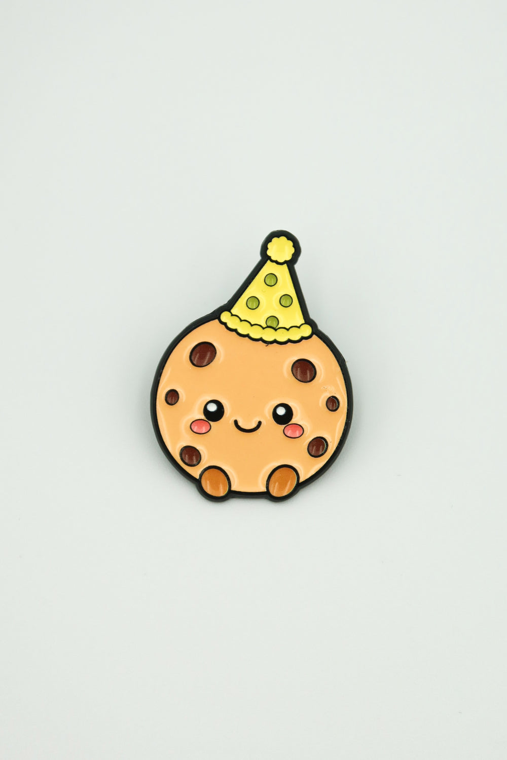 cookiegrips 1st Anniversary Enamel Pin with cookie mascot wearing a yellow party hat