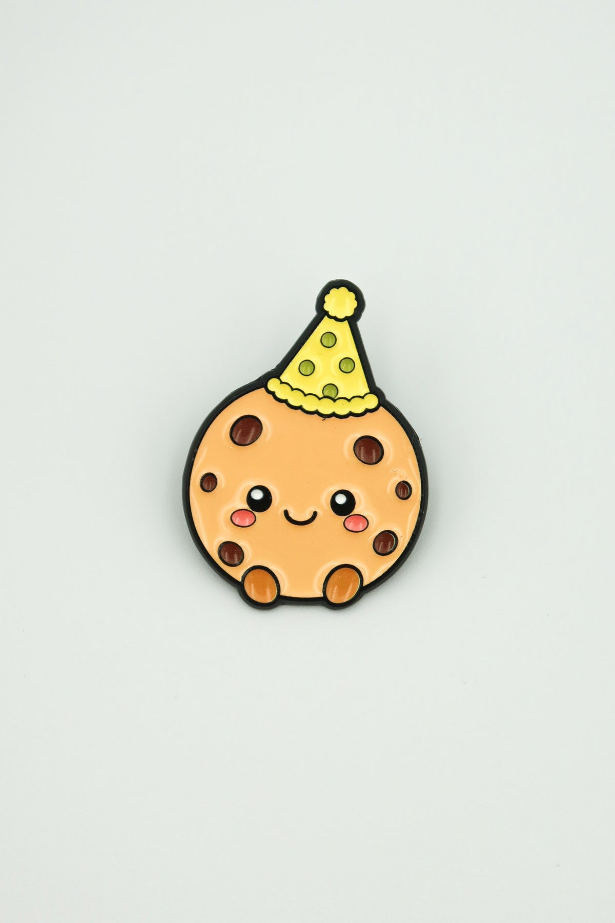 cookiegrips 1st Anniversary Enamel Pin with cookie mascot wearing a yellow party hat