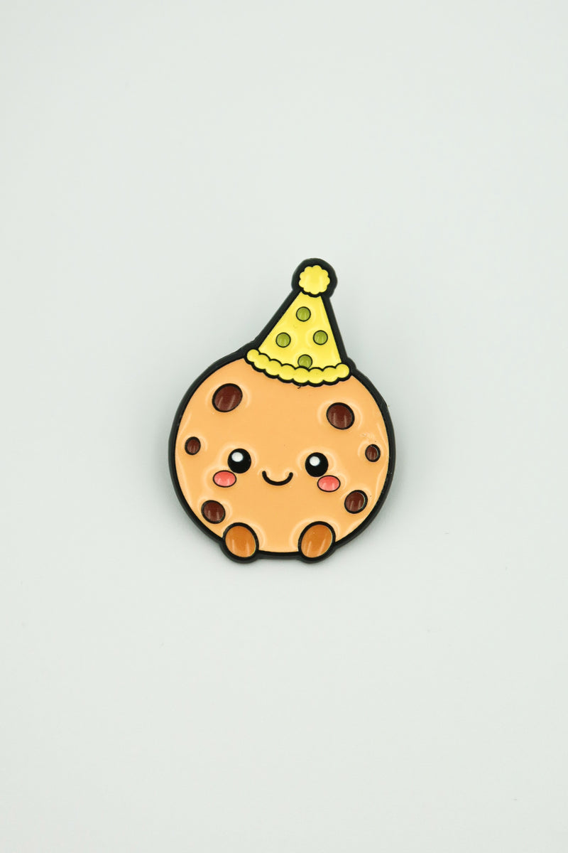 cookiegrips 1st Anniversary Enamel Pin with cookie mascot wearing a yellow party hat