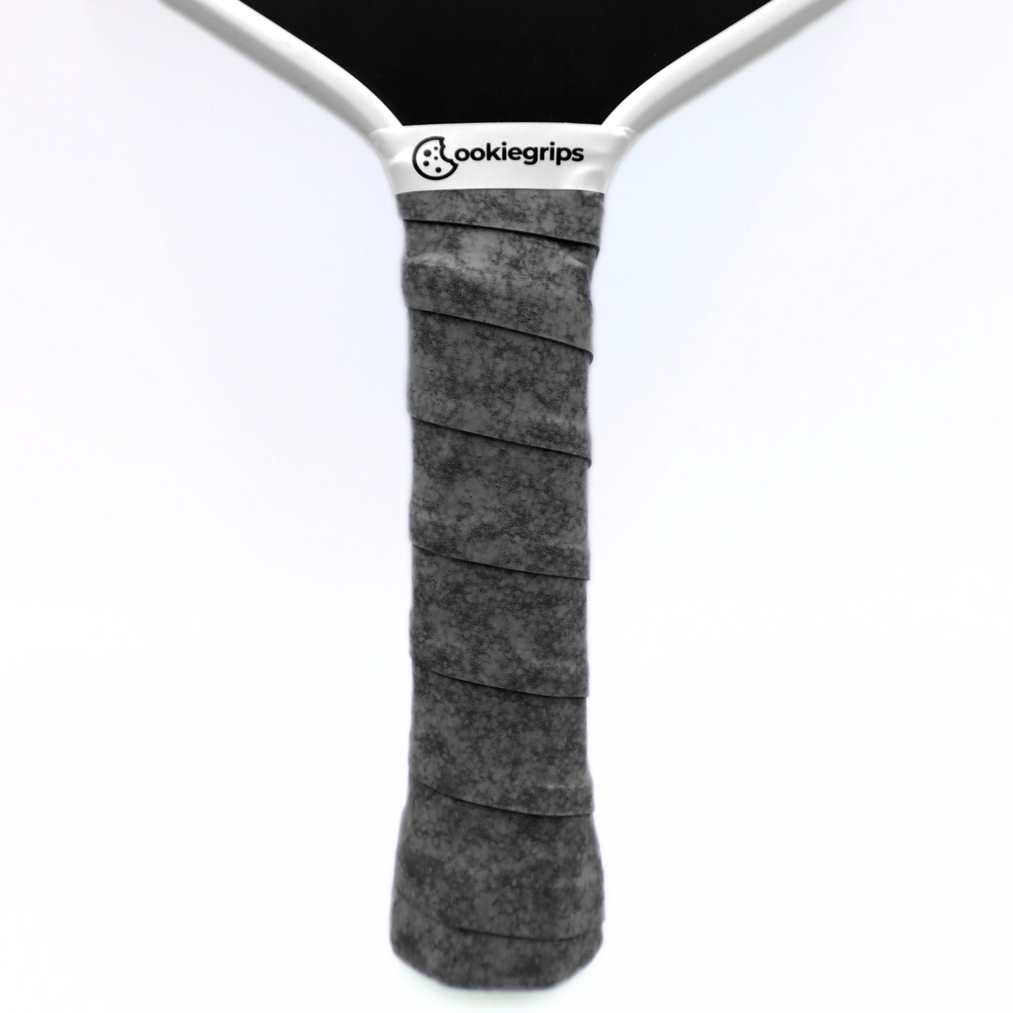 Cookiegrips Tough Cookie pickleball paddle handle wrapped with speckled grey overgrip, showing textured dry grip and clean white paddle throat.