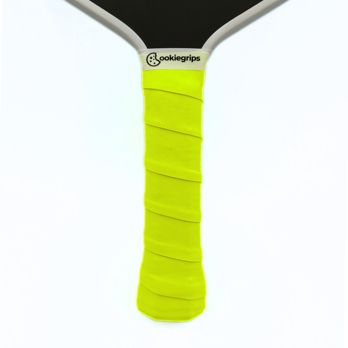 Cookiegrips Tough Cookie pickleball paddle handle wrapped with yellow overgrip, showing textured dry grip and clean white paddle throat.